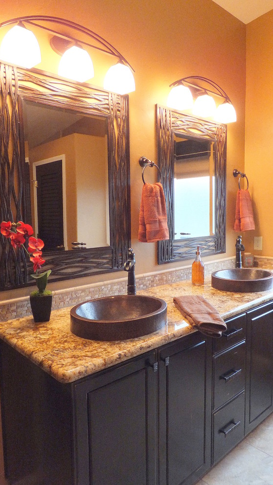 This is an example of a large rustic ensuite bathroom in Phoenix with a vessel sink, shaker cabinets, dark wood cabinets, granite worktops, beige tiles, stone tiles and brown walls.