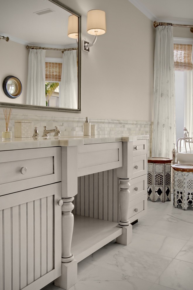 На фото: главная ванная комната среднего размера в классическом стиле с фасадами островного типа, белыми фасадами, отдельно стоящей ванной, душем в нише, раздельным унитазом, белой плиткой, мраморной плиткой, бежевыми стенами, мраморным полом, врезной раковиной, мраморной столешницей, белым полом, душем с распашными дверями и белой столешницей с