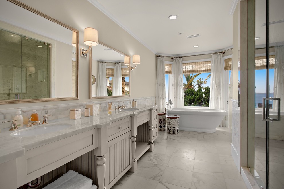 Свежая идея для дизайна: главная ванная комната среднего размера в классическом стиле с белыми фасадами, отдельно стоящей ванной, душем в нише, белой плиткой, бежевыми стенами, врезной раковиной, мраморным полом, мраморной столешницей, душем с распашными дверями, раздельным унитазом, мраморной плиткой, белым полом, белой столешницей и фасадами в стиле шейкер - отличное фото интерьера