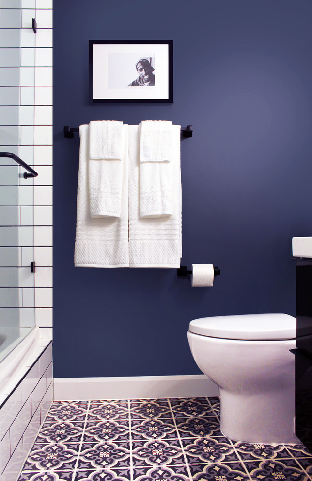 Photo of a small modern shower room bathroom in Toronto with flat-panel cabinets, black cabinets, a built-in bath, a shower/bath combination, a one-piece toilet, white tiles, ceramic tiles, blue walls, ceramic flooring, a built-in sink, marble worktops, blue floors, an open shower, white worktops, a single sink and a floating vanity unit.