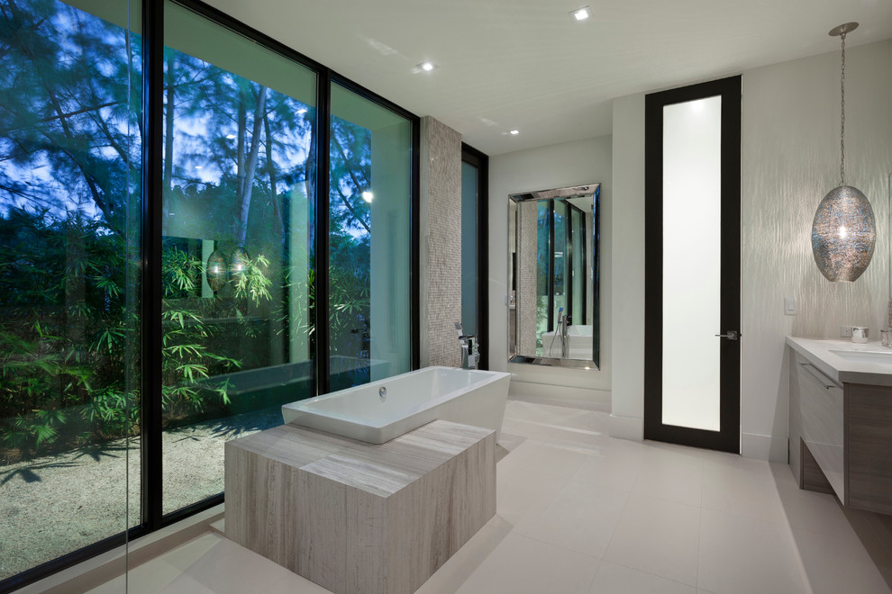 Inspiration pour une très grande salle de bain principale design avec un placard à porte plane, une baignoire indépendante, une douche ouverte, un carrelage gris, un carrelage de pierre et un sol en carrelage de porcelaine.