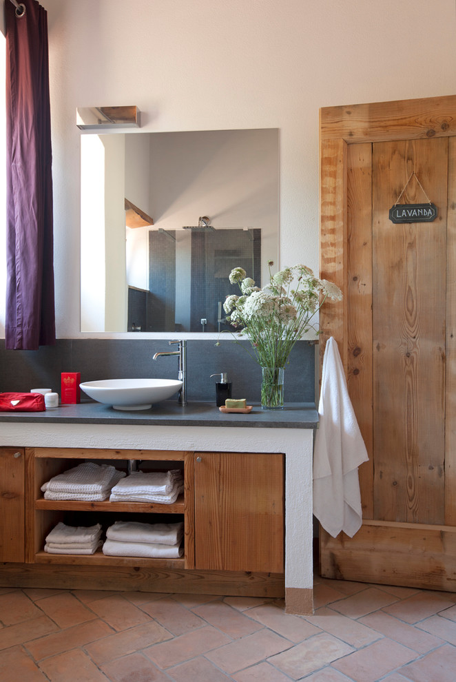 На фото: ванная комната в стиле кантри с светлыми деревянными фасадами и полом из терракотовой плитки