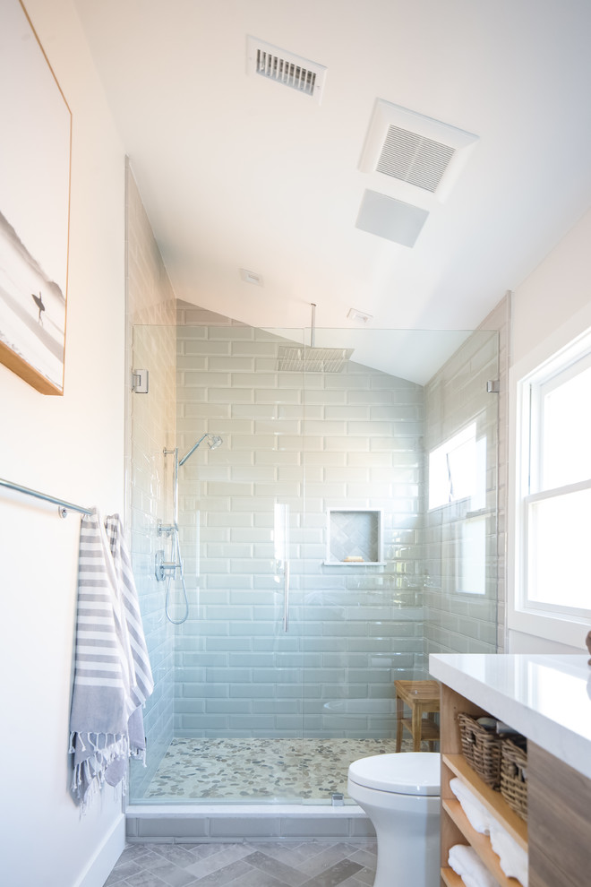 Exemple d'une douche en alcôve bord de mer en bois foncé avec un placard à porte plane, un mur blanc, un sol gris, une cabine de douche à porte battante et un plan de toilette blanc.
