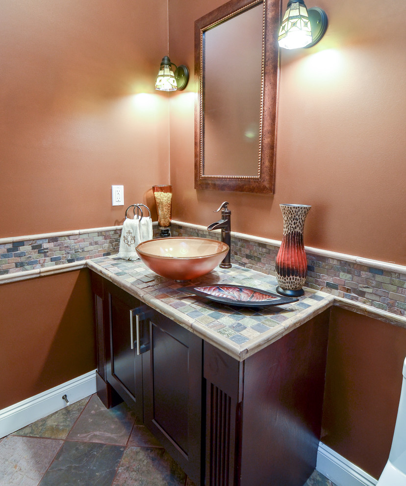 Example of a small classic 3/4 multicolored tile and ceramic tile concrete floor bathroom design in Vancouver with recessed-panel cabinets, dark wood cabinets, a vessel sink, beige walls and tile countertops