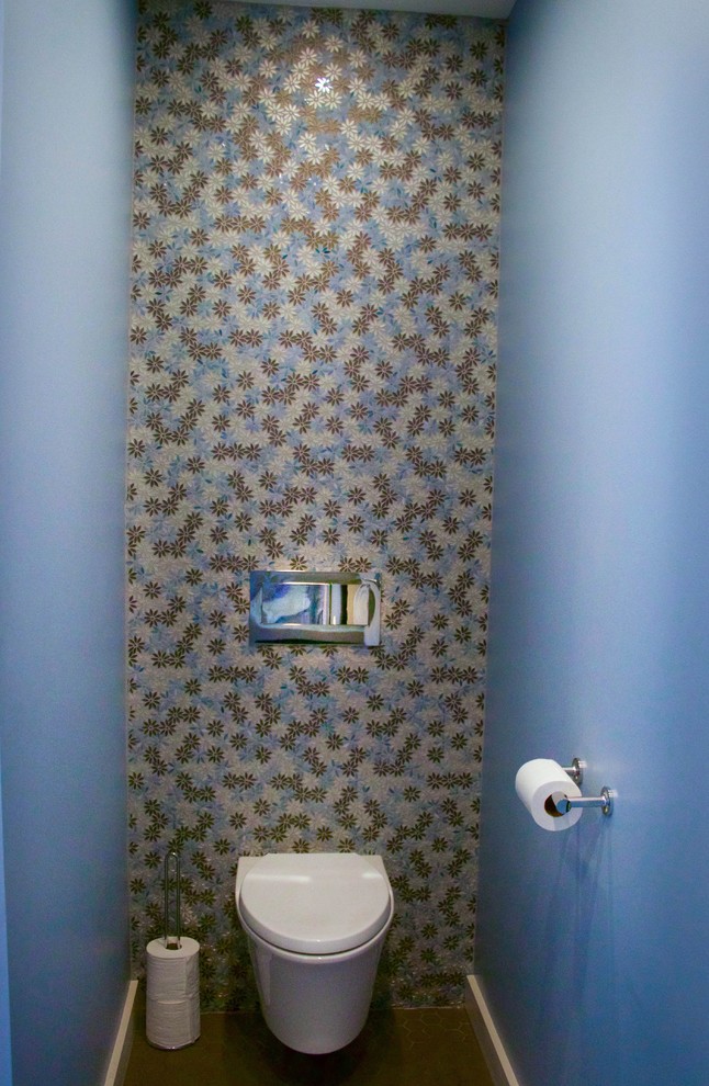 Cette photo montre un WC suspendu chic de taille moyenne avec un placard à porte shaker, des portes de placard blanches, un carrelage bleu, des plaques de verre, un mur bleu, un sol en carrelage de porcelaine, un lavabo encastré et un plan de toilette en quartz modifié.