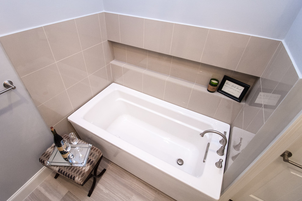 На фото: большая главная ванная комната в стиле неоклассика (современная классика) с отдельно стоящей ванной, бежевой плиткой, керамогранитной плиткой, серыми стенами и полом из керамической плитки с