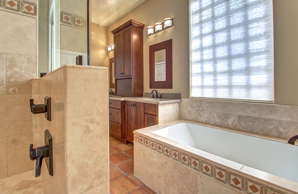 Inspiration for a large classic ensuite bathroom in Phoenix with shaker cabinets, medium wood cabinets, a submerged bath, a two-piece toilet, beige tiles, stone tiles, beige walls, travertine flooring and engineered stone worktops.