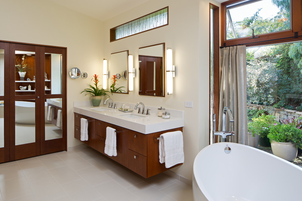 Immagine di una stanza da bagno padronale american style con ante lisce, ante in legno bruno, vasca freestanding, pareti beige e lavabo sottopiano
