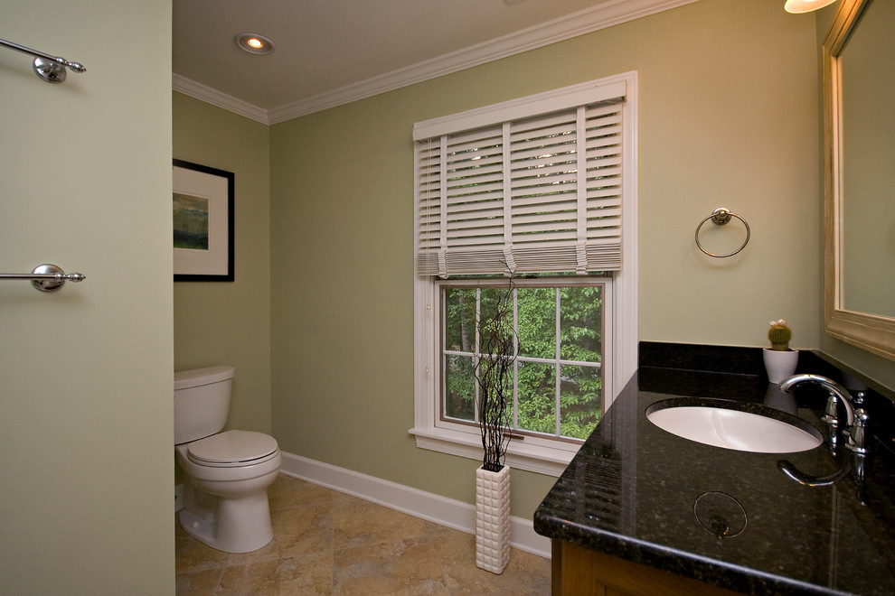 Idéer för ett mellanstort klassiskt grön en-suite badrum, med luckor med upphöjd panel, skåp i mellenmörkt trä, en dusch i en alkov, en toalettstol med separat cisternkåpa, beige kakel, cementkakel, gröna väggar, cementgolv, ett undermonterad handfat, granitbänkskiva, flerfärgat golv och dusch med gångjärnsdörr