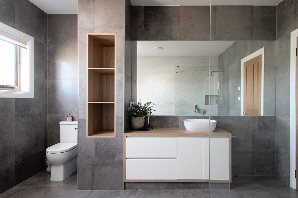 Inspiration for a large modern ensuite bathroom in Hobart with white cabinets, a freestanding bath, a walk-in shower, grey tiles, porcelain tiles, grey walls, porcelain flooring, a console sink, laminate worktops, grey floors, an open shower and brown worktops.