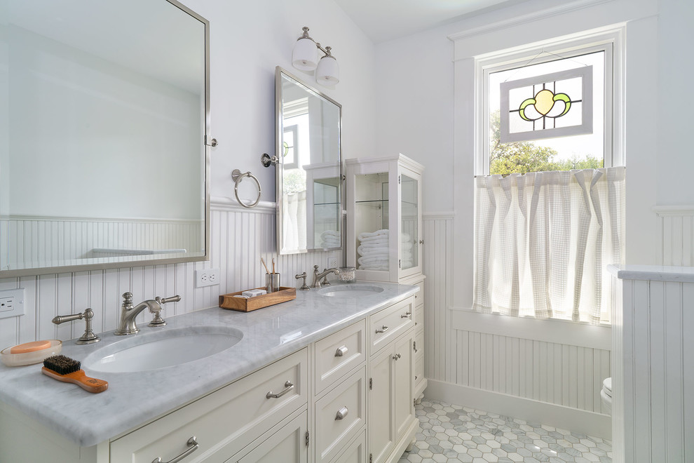 Cette image montre une salle de bain victorienne de taille moyenne avec une baignoire sur pieds, un mur blanc, un lavabo encastré, un sol gris, un plan de toilette gris et un plan de toilette en marbre.