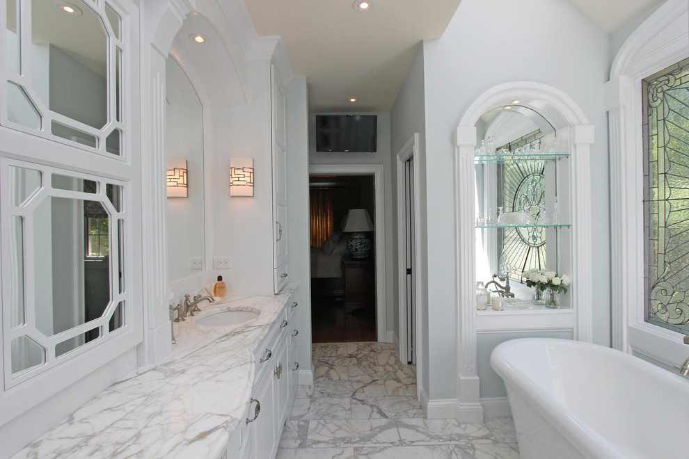 Свежая идея для дизайна: главная ванная комната среднего размера в классическом стиле с фасадами с выступающей филенкой, белыми фасадами, отдельно стоящей ванной, столешницей из гранита, серой столешницей, душем в нише, серой плиткой, мраморной плиткой, серыми стенами, мраморным полом, врезной раковиной, серым полом и душем с распашными дверями - отличное фото интерьера
