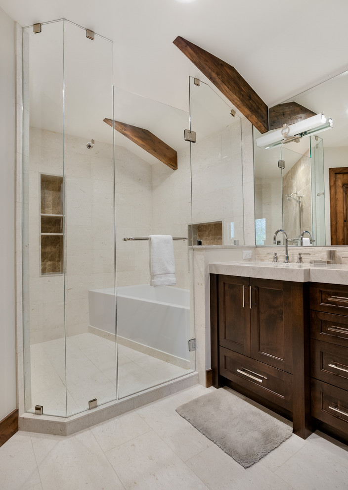 Photo of a medium sized rustic wet room bathroom in Salt Lake City with recessed-panel cabinets, dark wood cabinets, white walls, porcelain flooring, a submerged sink, marble worktops, white floors, a hinged door, an alcove bath and beige worktops.