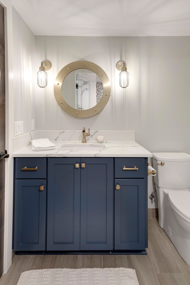 Пример оригинального дизайна: ванная комната в стиле неоклассика (современная классика) с плоскими фасадами, синими фасадами, унитазом-моноблоком, серыми стенами, полом из керамической плитки, душевой кабиной, врезной раковиной, серым полом и белой столешницей