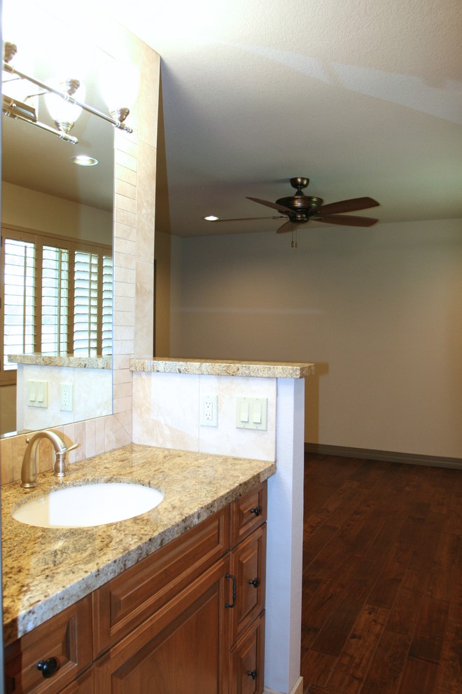 Idée de décoration pour une salle de bain design en bois brun de taille moyenne avec un lavabo encastré, un placard avec porte à panneau surélevé, un plan de toilette en granite, une douche double, un carrelage beige, un mur beige et un sol en travertin.