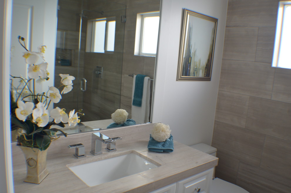 Modern inredning av ett litet beige beige badrum med dusch, med luckor med upphöjd panel, vita skåp, en toalettstol med hel cisternkåpa, flerfärgad kakel, keramikplattor, grå väggar, ett undermonterad handfat, bänkskiva i täljsten, en dusch i en alkov, dusch med gångjärnsdörr, mosaikgolv, flerfärgat golv och ett fristående badkar
