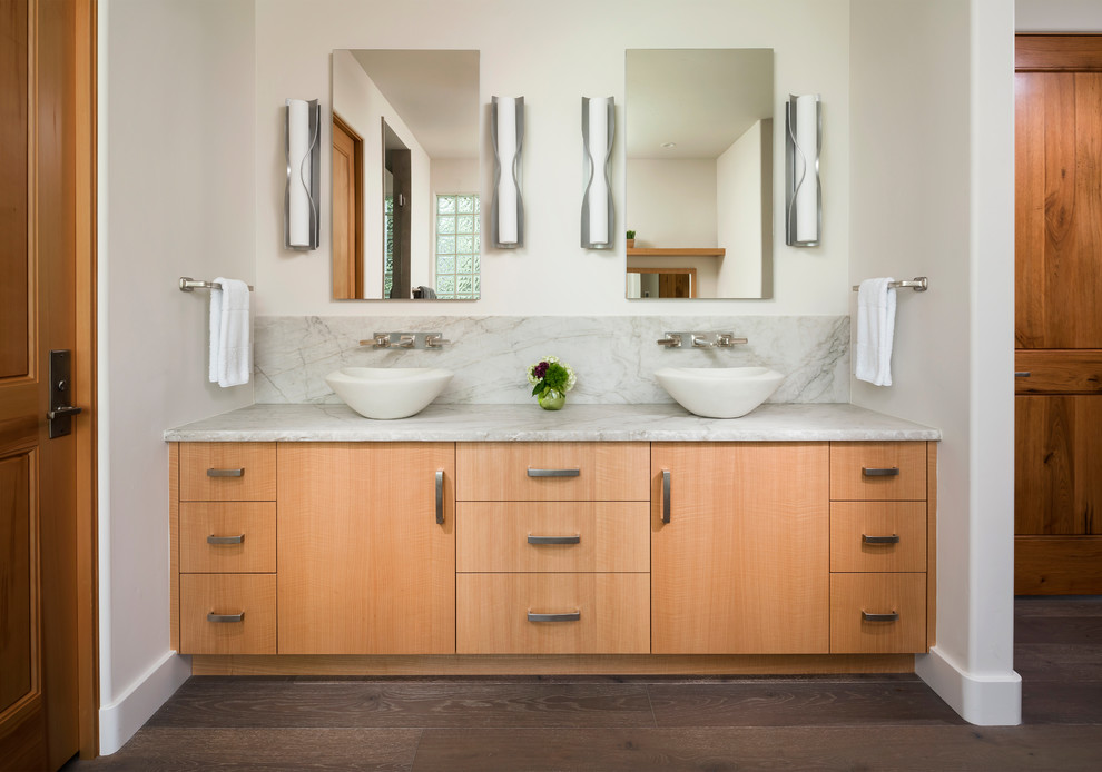 Diseño de cuarto de baño contemporáneo con armarios con paneles lisos, puertas de armario de madera oscura, paredes blancas, lavabo sobreencimera, suelo marrón y encimeras blancas