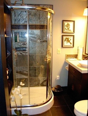 Example of a small classic 3/4 black tile and glass tile corner shower design in Seattle with beige walls, a vessel sink, flat-panel cabinets, dark wood cabinets and limestone countertops