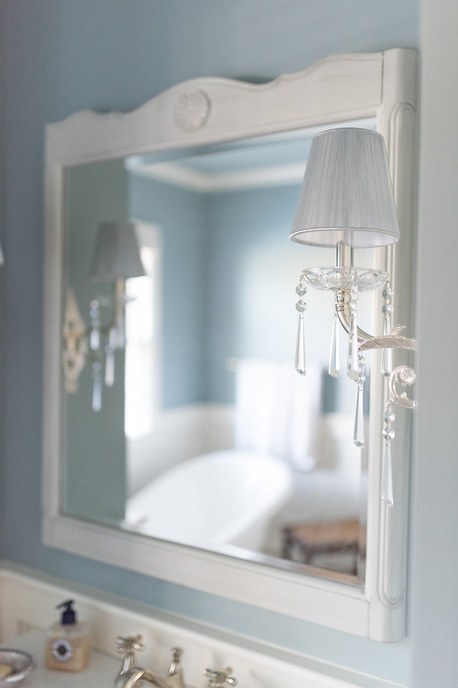 Inredning av ett klassiskt mellanstort vit vitt en-suite badrum, med vita skåp, ett badkar med tassar, mellanmörkt trägolv, ett undermonterad handfat, brunt golv, luckor med infälld panel, blå väggar och bänkskiva i akrylsten