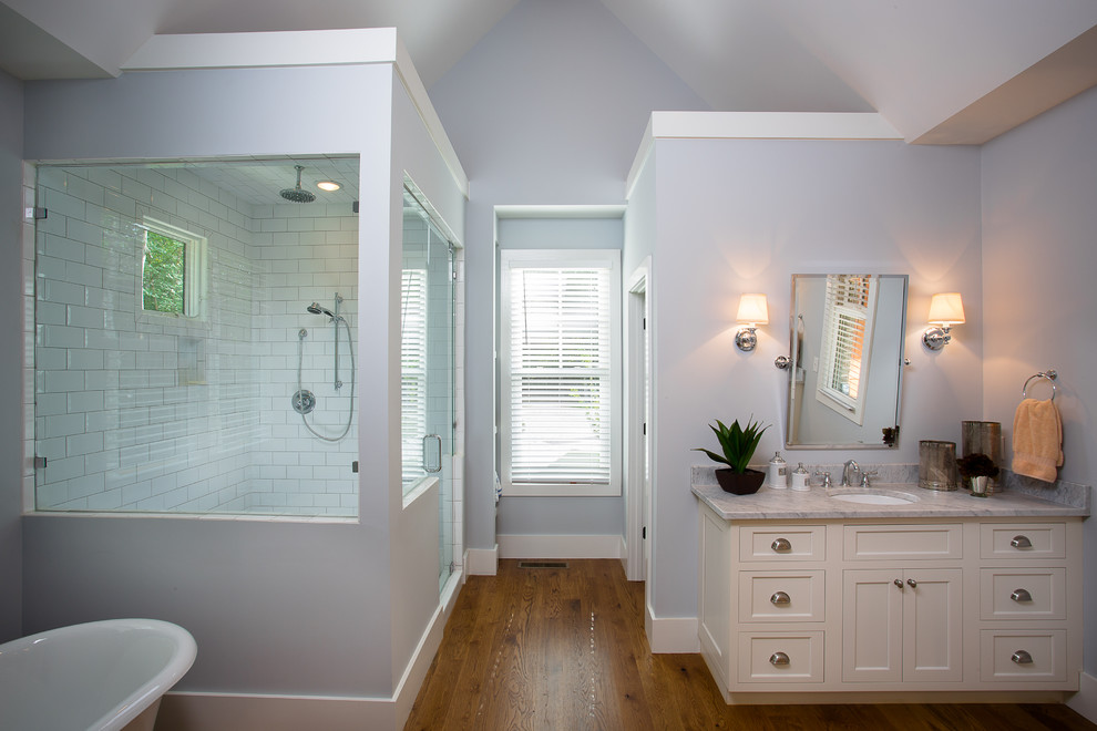 Idéer för att renovera ett mellanstort vintage en-suite badrum, med skåp i shakerstil, vita skåp, ett fristående badkar, våtrum, vit kakel, tunnelbanekakel, blå väggar, mellanmörkt trägolv, ett undermonterad handfat, marmorbänkskiva, beiget golv och dusch med gångjärnsdörr
