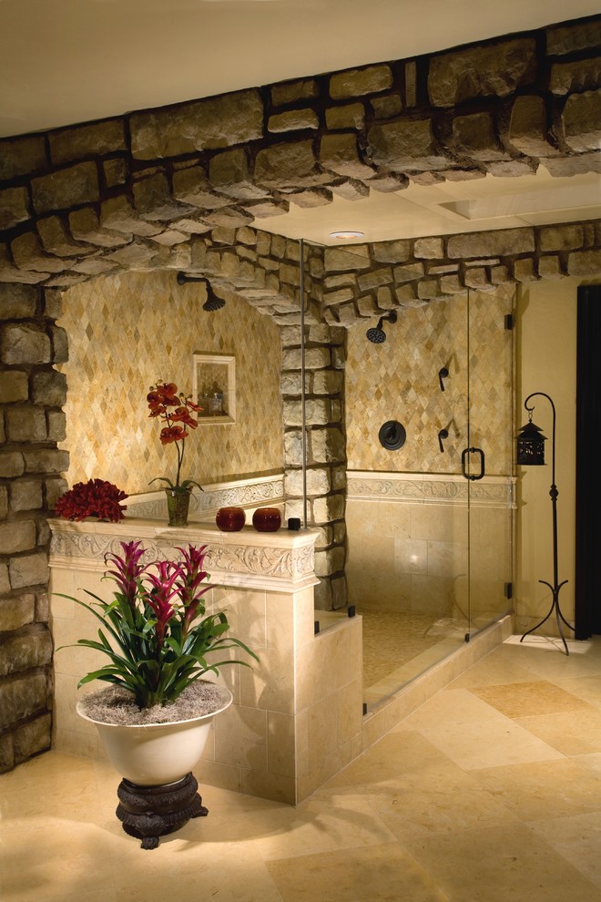Example of a large tuscan master travertine floor and beige floor double shower design in Orange County with raised-panel cabinets, dark wood cabinets, beige walls, a drop-in sink, granite countertops and a hinged shower door