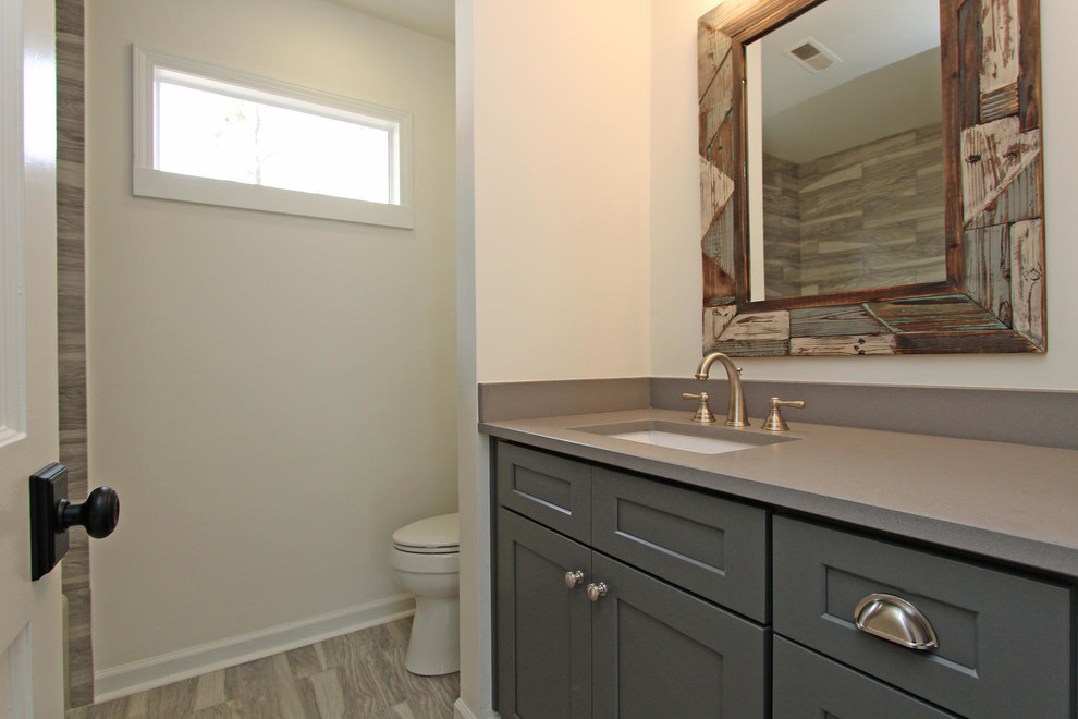 Идея дизайна: ванная комната среднего размера в стиле фьюжн с плоскими фасадами, серыми фасадами, отдельно стоящей ванной, белыми стенами, полом из керамической плитки и врезной раковиной