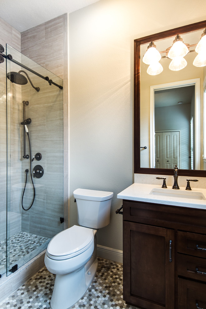 Inredning av ett klassiskt badrum, med klinkergolv i porslin, ett undermonterad handfat, bänkskiva i kvarts, skåp i shakerstil, skåp i mörkt trä, beige kakel, porslinskakel, bruna väggar, flerfärgat golv och dusch med skjutdörr