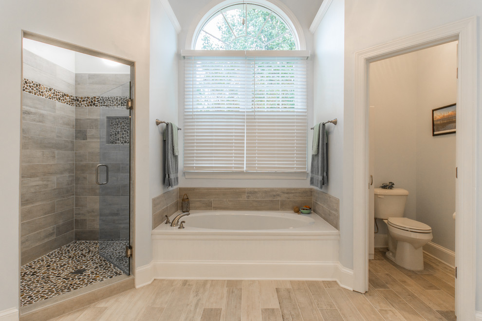 Diseño de cuarto de baño tradicional con bañera empotrada, ducha esquinera, sanitario de dos piezas y suelo de baldosas tipo guijarro