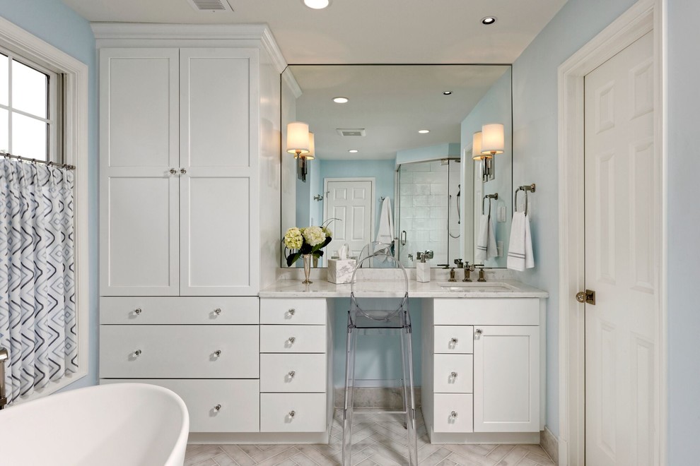 This is an example of a medium sized classic ensuite bathroom in DC Metro with recessed-panel cabinets, white cabinets, a freestanding bath, a corner shower, beige tiles, white tiles, ceramic tiles, blue walls, marble flooring, a submerged sink and marble worktops.