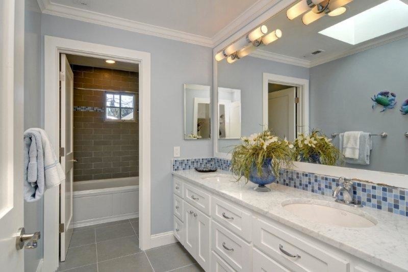 Стильный дизайн: ванная комната в современном стиле с врезной раковиной, фасадами в стиле шейкер, белыми фасадами, мраморной столешницей, ванной в нише, душем над ванной, унитазом-моноблоком, серой плиткой и плиткой мозаикой - последний тренд