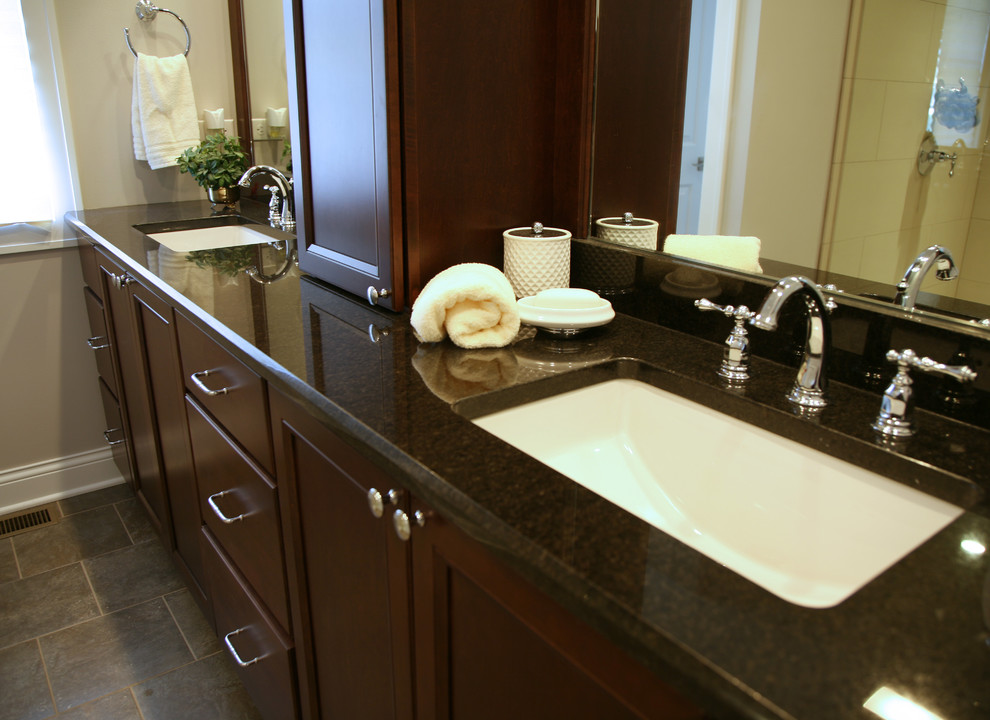 Medium sized classic ensuite bathroom in Milwaukee with a submerged sink, flat-panel cabinets, medium wood cabinets, granite worktops, a walk-in shower, a one-piece toilet, grey tiles, ceramic tiles, grey walls and ceramic flooring.