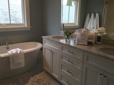 Example of a transitional ceramic tile and white floor freestanding bathtub design in Minneapolis with granite countertops