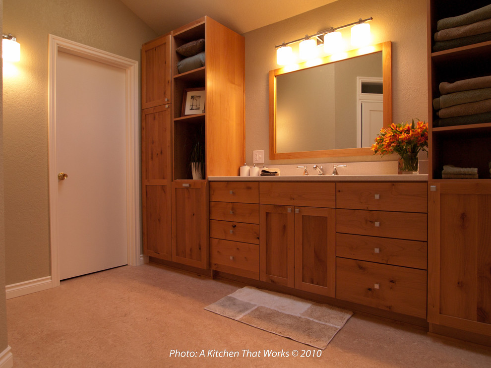Photo of a large classic ensuite bathroom in Seattle with a submerged sink, shaker cabinets, medium wood cabinets, solid surface worktops, a freestanding bath, an alcove shower, a two-piece toilet, green walls, lino flooring, beige floors, white worktops, an enclosed toilet, a single sink, a built in vanity unit and a vaulted ceiling.