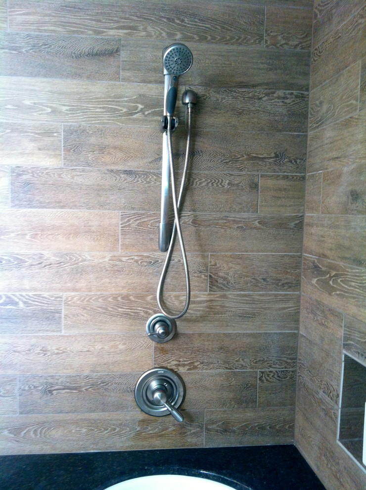 Exempel på ett mellanstort modernt en-suite badrum, med ett väggmonterat handfat, ett fristående badkar, en öppen dusch och stenkakel