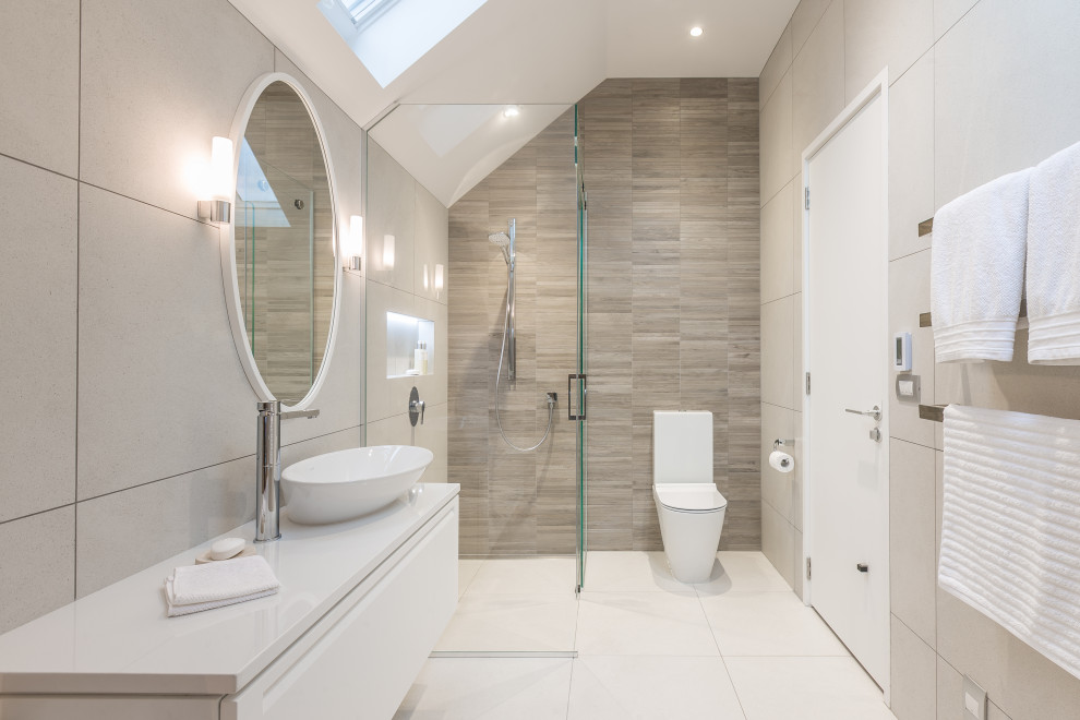 Foto di una stanza da bagno contemporanea di medie dimensioni con ante lisce, ante bianche, doccia ad angolo, piastrelle grigie, lavabo a bacinella, pavimento bianco e top bianco