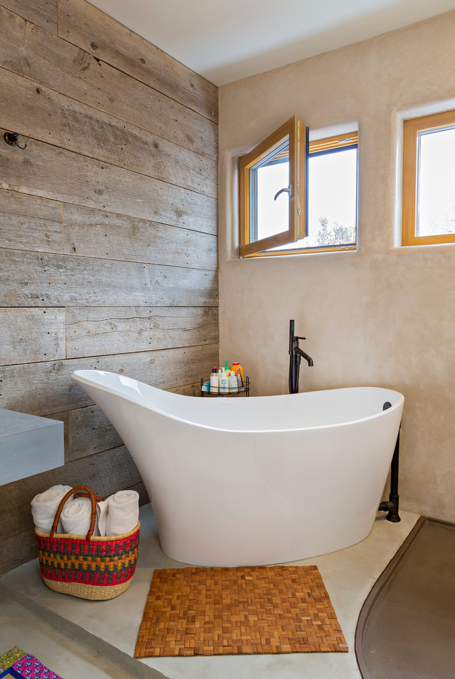 Imagen de cuarto de baño principal de estilo americano de tamaño medio con bañera exenta, paredes marrones, suelo de cemento, lavabo bajoencimera, encimera de cemento, suelo gris y encimeras grises