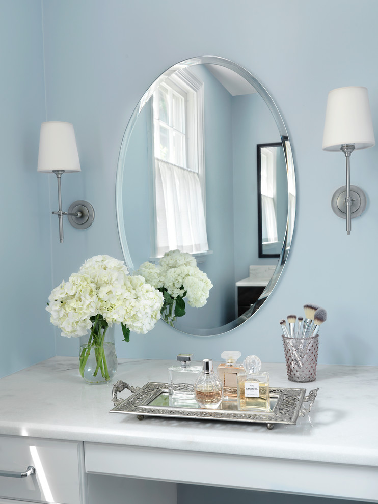 Cette image montre une grande salle de bain principale traditionnelle en bois foncé avec un placard à porte shaker, un plan de toilette en marbre, WC à poser, un carrelage blanc et un mur bleu.