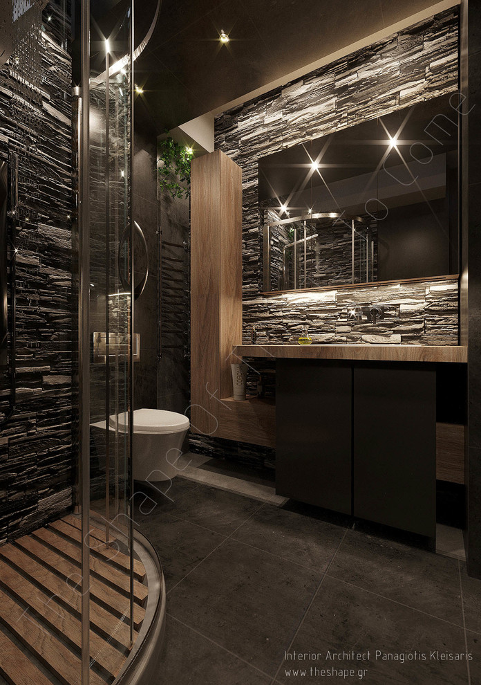 Cette image montre une salle de bain principale minimaliste de taille moyenne avec un placard à porte vitrée, des portes de placard grises, un carrelage gris, un carrelage de pierre et un plan de toilette en bois.