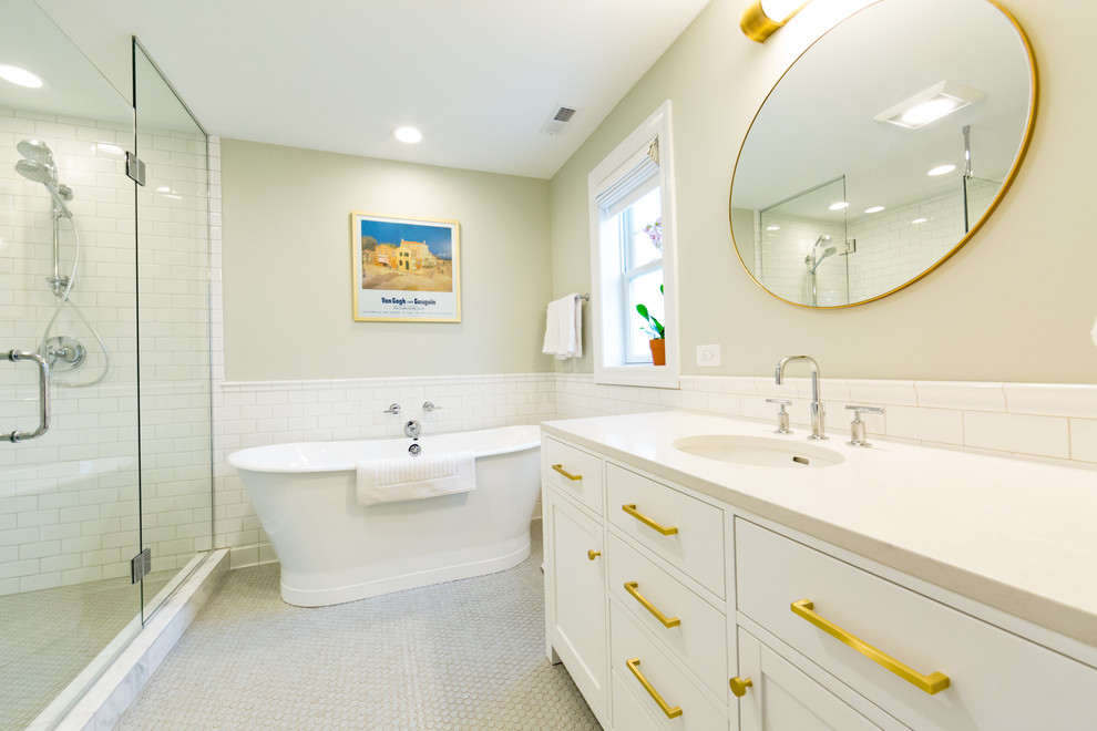 Идея дизайна: главная ванная комната: освещение в стиле неоклассика (современная классика) с фасадами в стиле шейкер, белыми фасадами, отдельно стоящей ванной, унитазом-моноблоком, керамической плиткой, серыми стенами, полом из керамической плитки, врезной раковиной, мраморной столешницей, белой плиткой и душем с распашными дверями