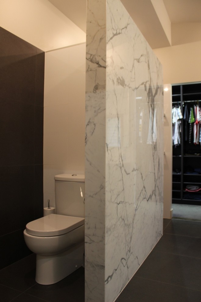 Bild på ett stort lantligt en-suite badrum, med ett integrerad handfat, luckor med infälld panel, svarta skåp, granitbänkskiva, ett platsbyggt badkar, en dusch i en alkov, en toalettstol med separat cisternkåpa, flerfärgad kakel, stenkakel, vita väggar och skiffergolv