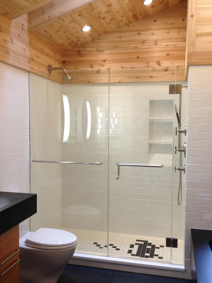 Inspiration for a large modern master white tile and ceramic tile slate floor alcove shower remodel in New York with flat-panel cabinets, medium tone wood cabinets, granite countertops, an undermount tub, a one-piece toilet and white walls