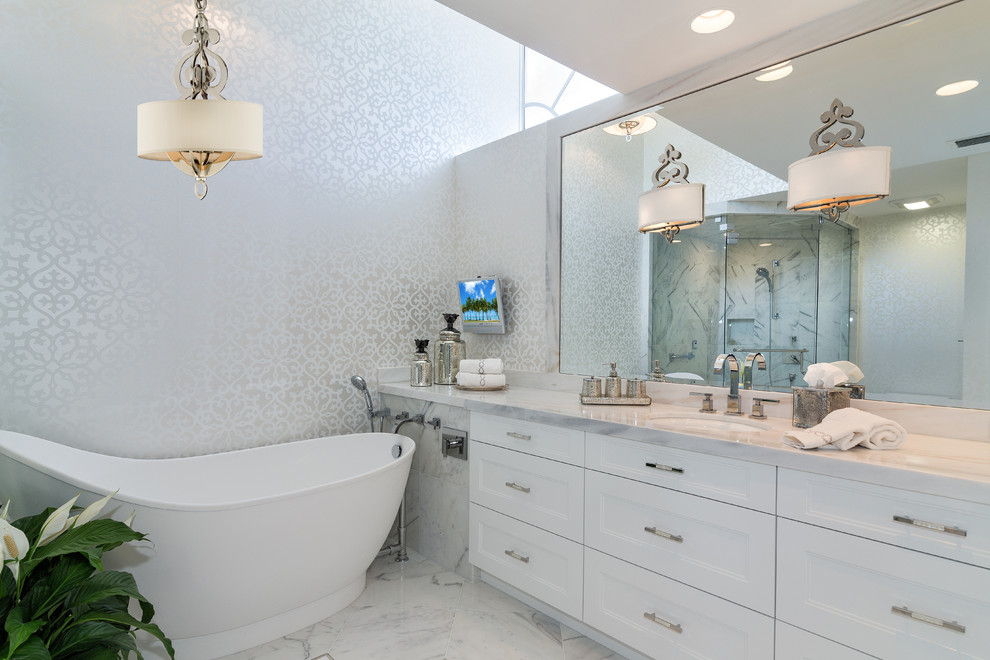 Idée de décoration pour une salle de bain design avec un lavabo encastré, un placard avec porte à panneau encastré, des portes de placard blanches, une baignoire indépendante et un carrelage blanc.