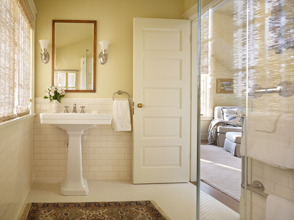 Corner shower - traditional mosaic tile floor corner shower idea in Seattle with a pedestal sink and yellow walls
