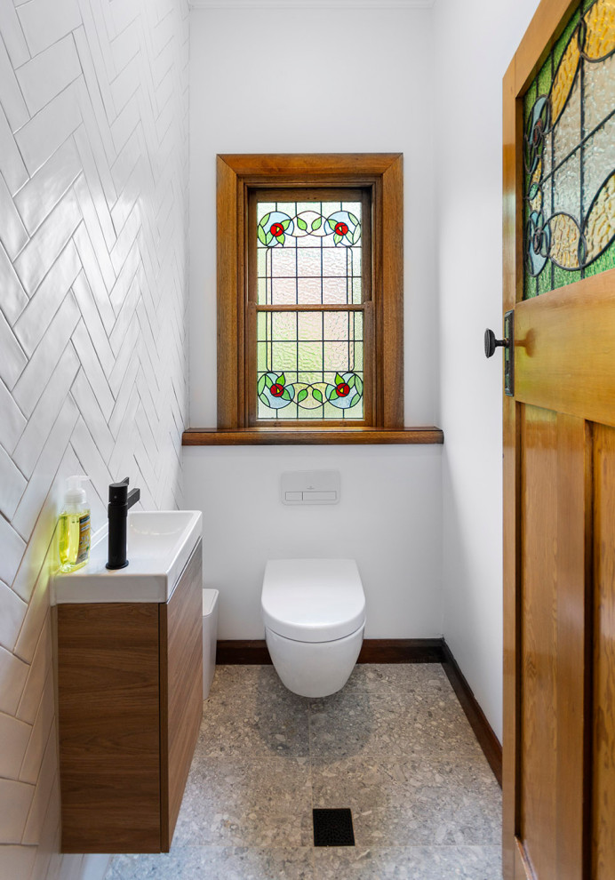 Idée de décoration pour un petit WC suspendu tradition en bois brun avec un placard à porte plane, un carrelage blanc, un carrelage métro, un mur blanc, un sol en terrazzo, un plan de toilette en quartz modifié, un sol gris, un plan de toilette blanc et meuble-lavabo suspendu.