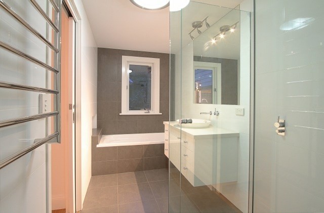Idée de décoration pour une salle de bain victorienne de taille moyenne avec un placard à porte plane, des portes de placard blanches, une baignoire en alcôve, une douche d'angle, un carrelage gris, un carrelage blanc, des carreaux de céramique, un mur blanc, un sol en carrelage de céramique, une vasque, un plan de toilette en granite et une cabine de douche à porte battante.