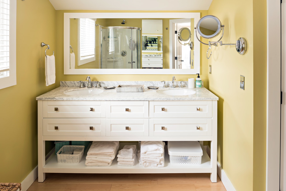 Стильный дизайн: ванная комната в классическом стиле с фасадами в стиле шейкер, белыми фасадами, желтыми стенами, светлым паркетным полом, врезной раковиной и серой столешницей - последний тренд