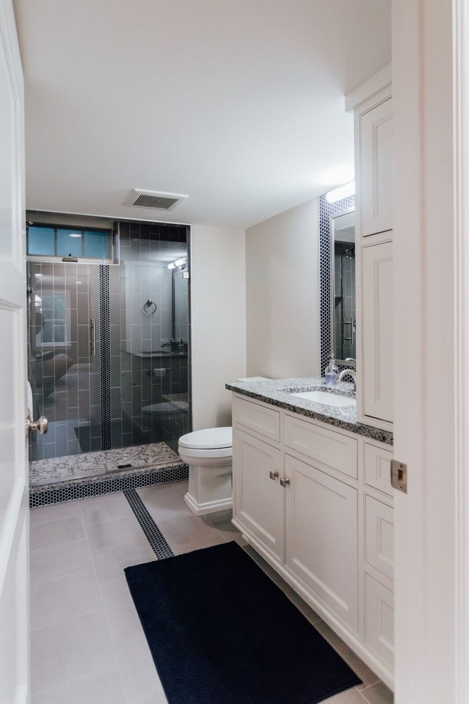 Идея дизайна: ванная комната среднего размера в стиле неоклассика (современная классика) с фасадами с утопленной филенкой, белыми фасадами, душем в нише, раздельным унитазом, серой плиткой, плиткой кабанчик, серыми стенами, душевой кабиной, врезной раковиной и столешницей из гранита