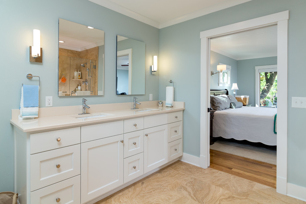 Photo of a medium sized classic ensuite bathroom in Atlanta with a submerged sink, shaker cabinets, white cabinets, solid surface worktops, a freestanding bath, an alcove shower, a one-piece toilet, beige tiles, mosaic tiles, blue walls and light hardwood flooring.