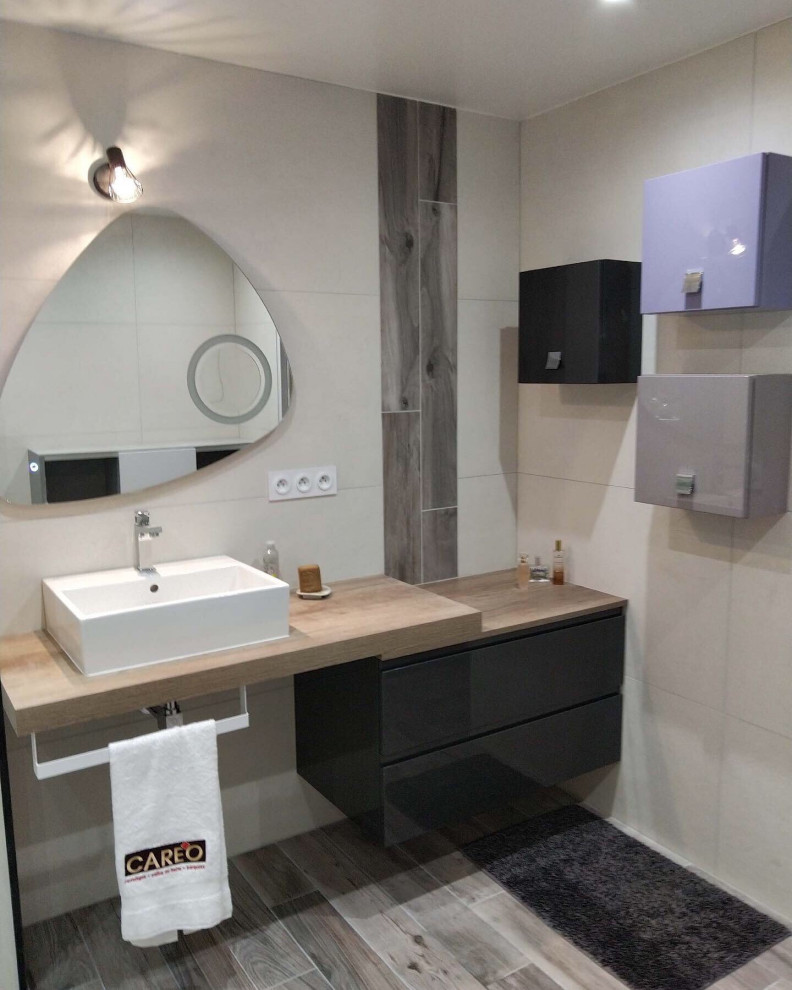 Foto på ett stort funkis beige en-suite badrum, med släta luckor, svarta skåp, en öppen dusch, beige kakel, vit kakel, grå kakel, cementkakel, ett avlångt handfat, träbänkskiva, grått golv och med dusch som är öppen