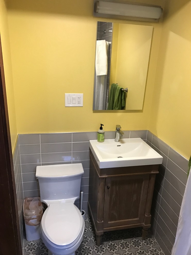 Inredning av ett modernt litet badrum, med möbel-liknande, skåp i slitet trä, en öppen dusch, en toalettstol med hel cisternkåpa, gul kakel, tunnelbanekakel, gula väggar, klinkergolv i keramik, ett nedsänkt handfat, flerfärgat golv och dusch med duschdraperi